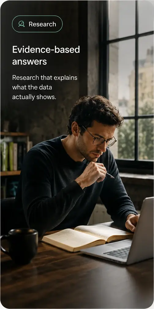 Research: a person reading at a desk beside a window, introducing the evidence behind our answers.